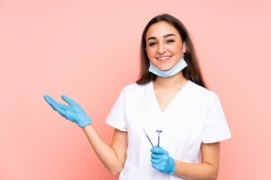 Female dental professional against a pink backdrop